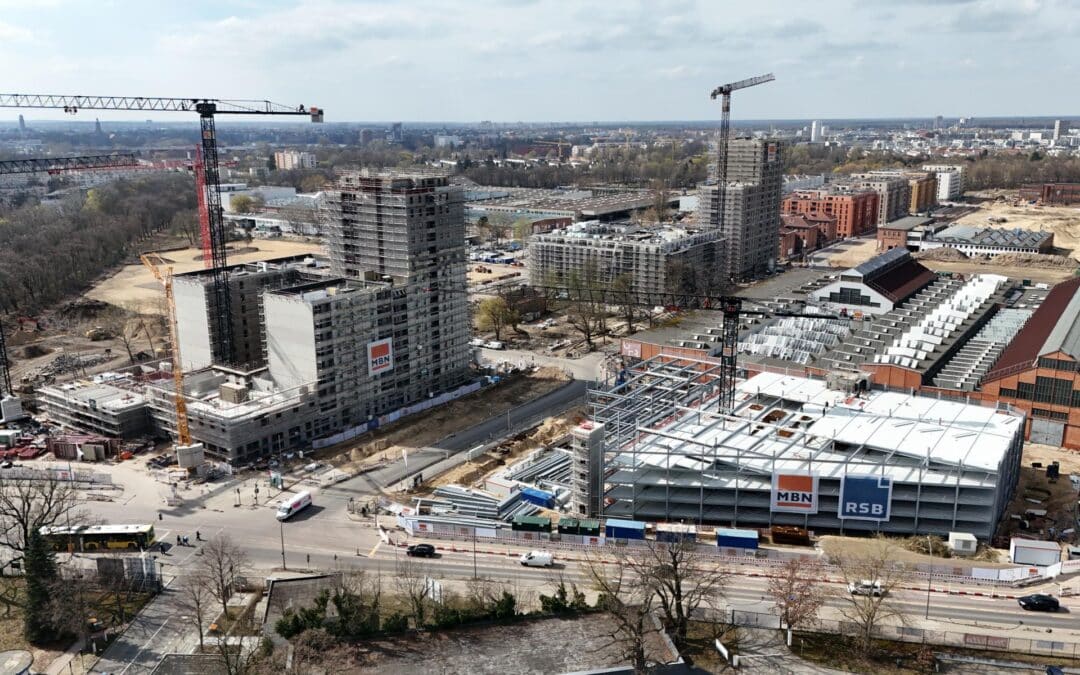 Drohnenaufnahme der DNG-Baustelle mit Hochhaus-Rohbau und mehreren Kränen, Zwischenstand